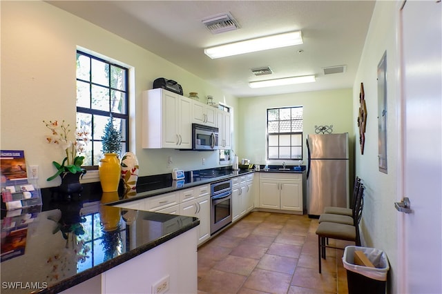 kitchen with white cabinets, stainless steel appliances, kitchen peninsula, and sink