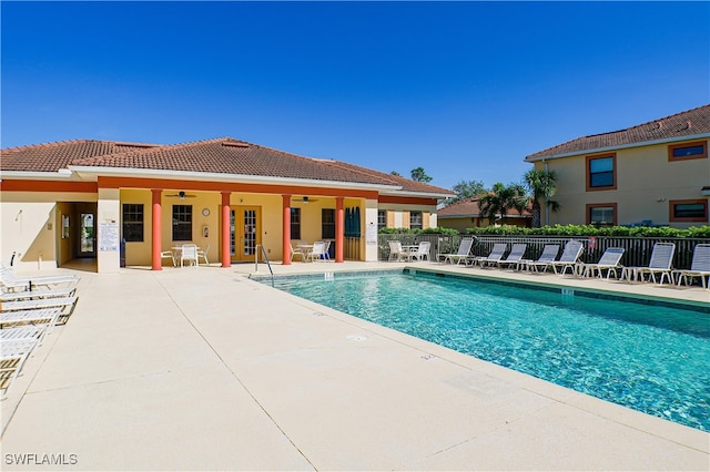 view of swimming pool with ceiling fan and a patio area