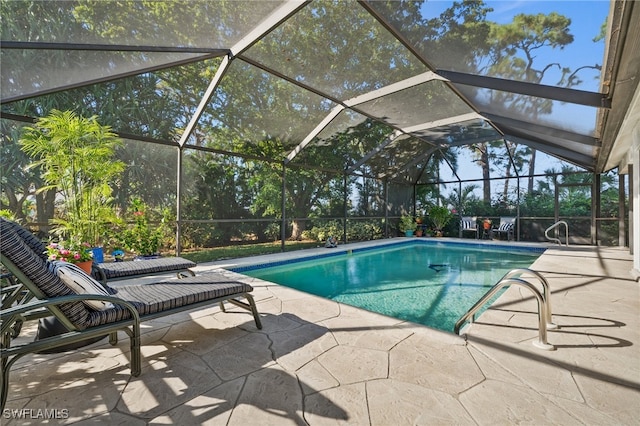 view of pool with glass enclosure and a patio