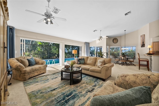 carpeted living room with high vaulted ceiling and ceiling fan