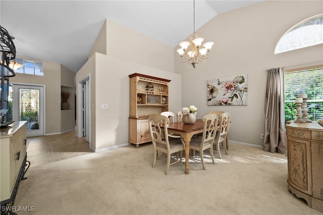 carpeted dining area featuring a chandelier and high vaulted ceiling