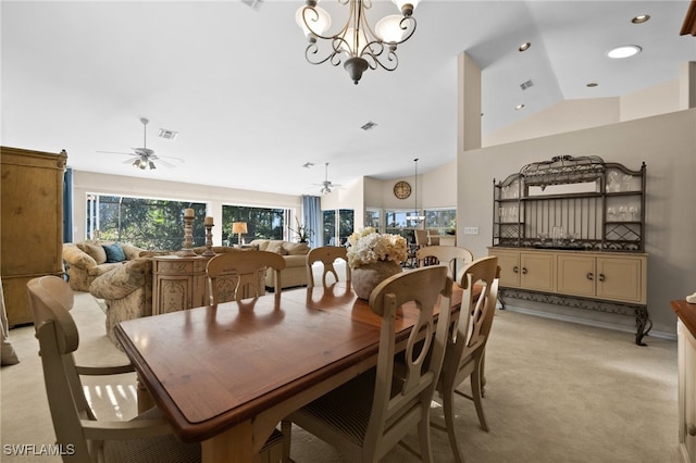 dining room with light colored carpet, lofted ceiling, and an inviting chandelier