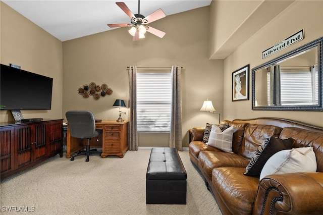 carpeted living room with ceiling fan and vaulted ceiling