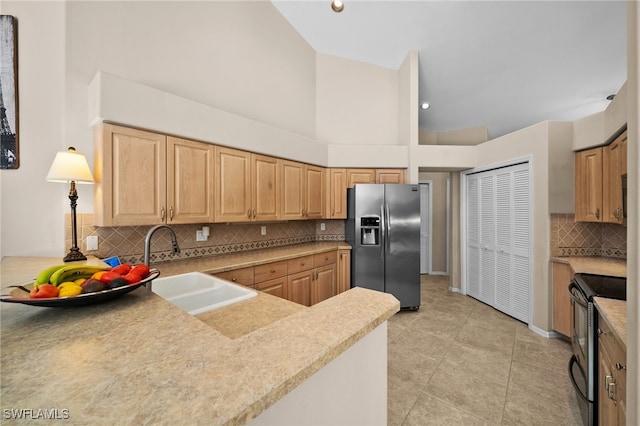 kitchen with sink, electric range, decorative backsplash, stainless steel fridge, and light tile patterned floors