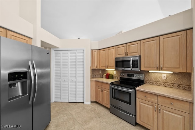 kitchen with decorative backsplash, appliances with stainless steel finishes, light tile patterned floors, and light brown cabinetry