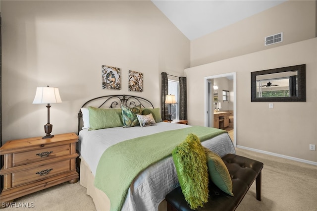 carpeted bedroom featuring connected bathroom and high vaulted ceiling