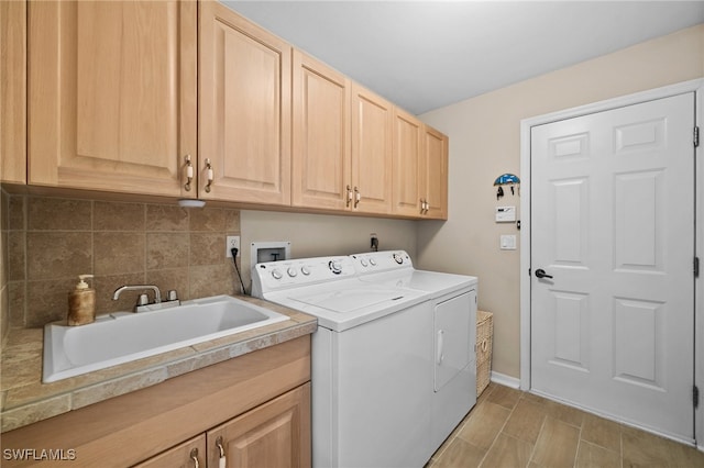 washroom featuring washer and clothes dryer, sink, and cabinets