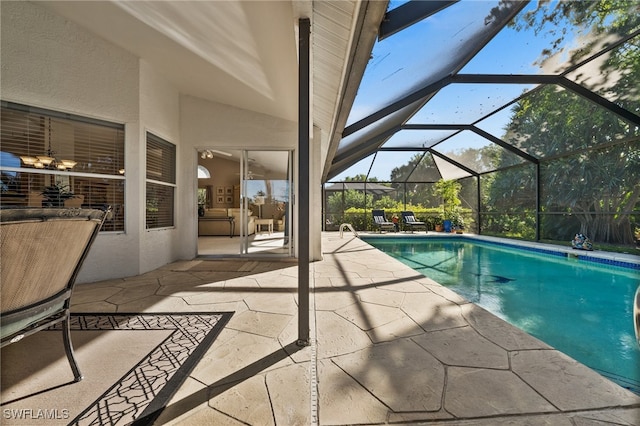 view of pool featuring glass enclosure and a patio area