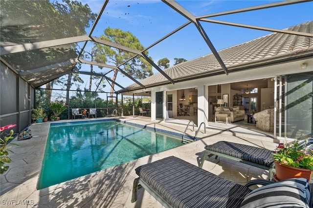 view of swimming pool with a patio area, an outdoor living space, and glass enclosure