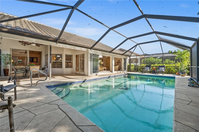 view of pool featuring a patio, glass enclosure, and ceiling fan