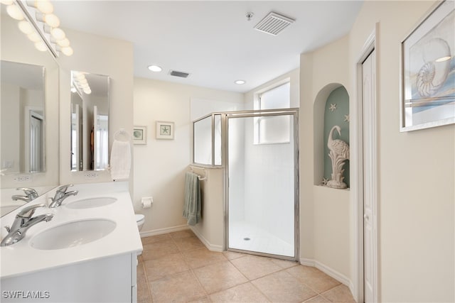 bathroom with tile patterned flooring, vanity, an enclosed shower, and toilet