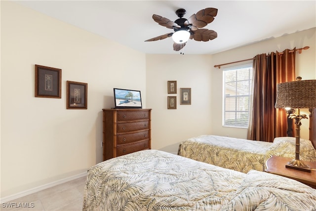 bedroom with light tile patterned floors, baseboards, and ceiling fan