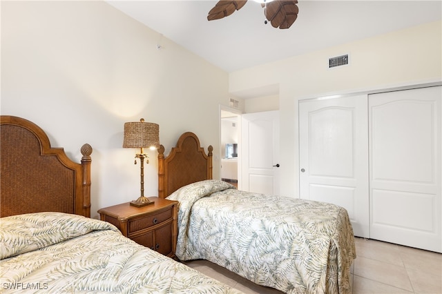 tiled bedroom featuring ceiling fan and a closet