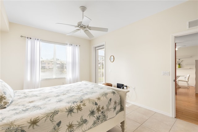 bedroom with light tile patterned floors, visible vents, baseboards, and a ceiling fan