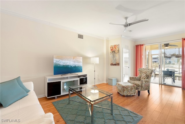 living room with crown molding, ceiling fan, and light hardwood / wood-style flooring