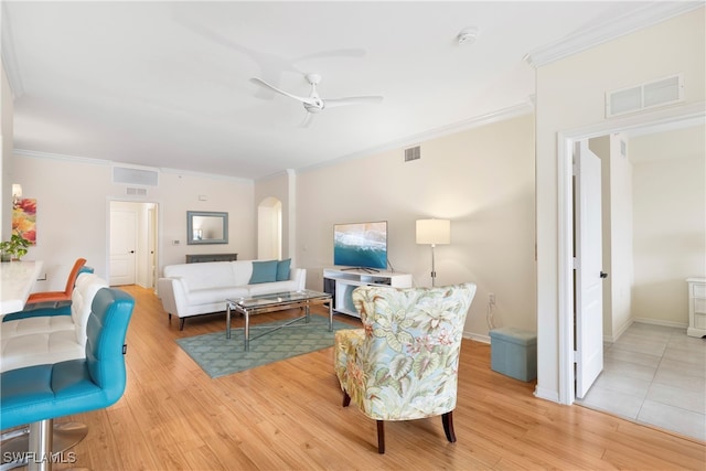 living room with crown molding, ceiling fan, and light hardwood / wood-style flooring