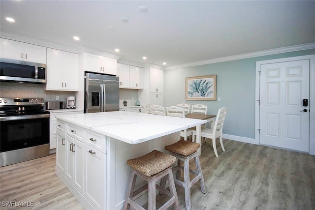 kitchen with a center island, white cabinetry, and stainless steel appliances