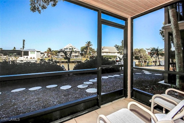 sunroom / solarium featuring a water view