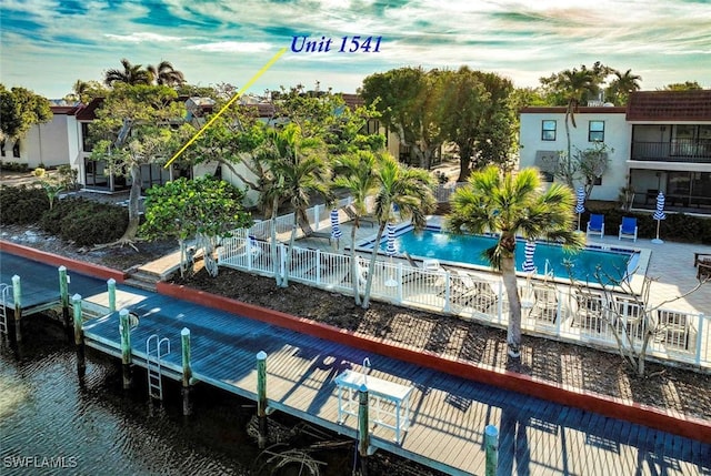 view of pool featuring a boat dock and a water view