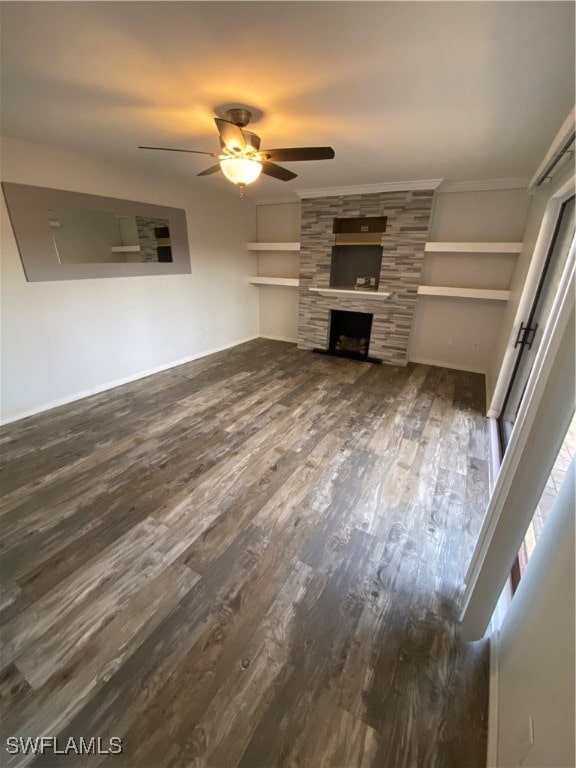 unfurnished living room featuring ceiling fan, dark hardwood / wood-style flooring, ornamental molding, and a fireplace