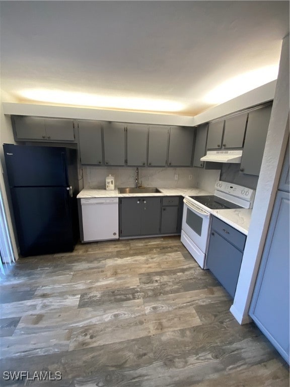 kitchen with gray cabinets, white appliances, and sink