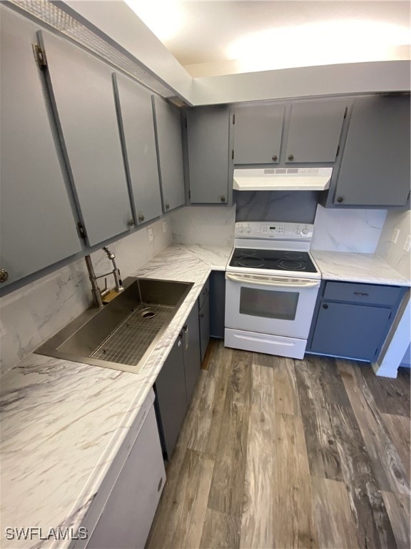 kitchen featuring sink, decorative backsplash, gray cabinets, white range with electric stovetop, and dark hardwood / wood-style flooring