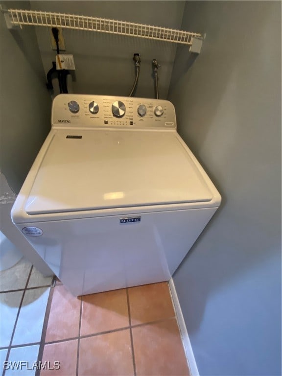 laundry area with tile patterned flooring and washer / dryer