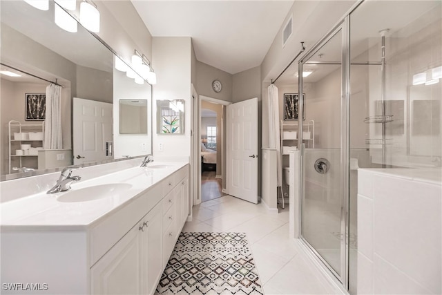 bathroom featuring tile patterned flooring, vanity, and a shower with shower door