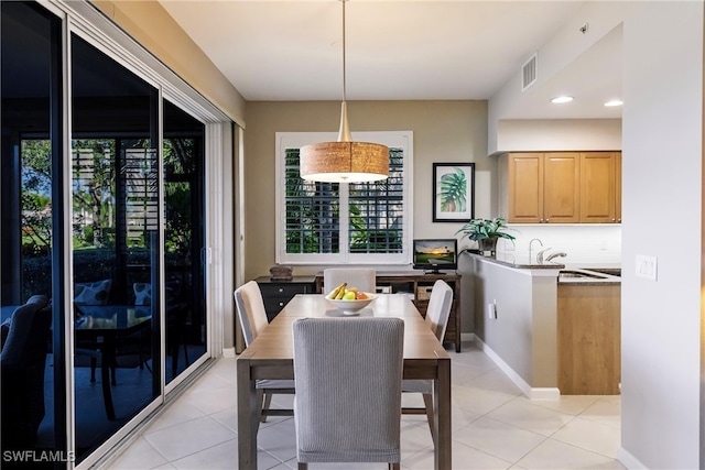 tiled dining space with a healthy amount of sunlight and sink