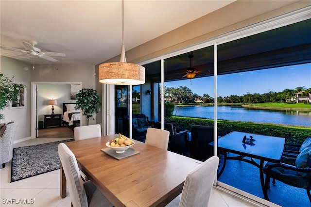 dining room featuring a water view and light tile patterned floors