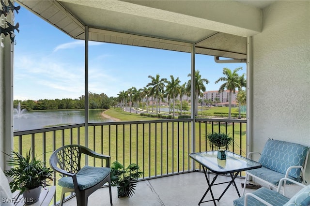 sunroom featuring a water view