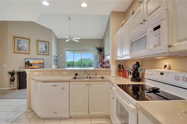 kitchen with light tile patterned floors, white appliances, vaulted ceiling, and sink