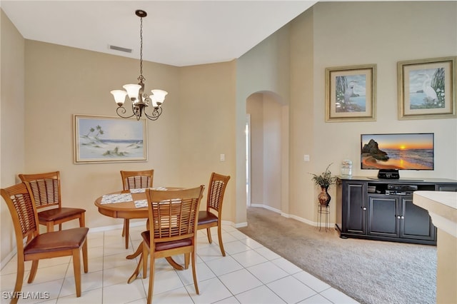 carpeted dining room with an inviting chandelier