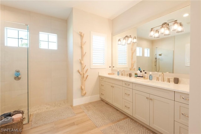 14248 Laguna Springs Ln, Naples, FL 34114 - bathroom featuring a walk in shower, double vanity, healthy amount of natural light, and wood finished floors