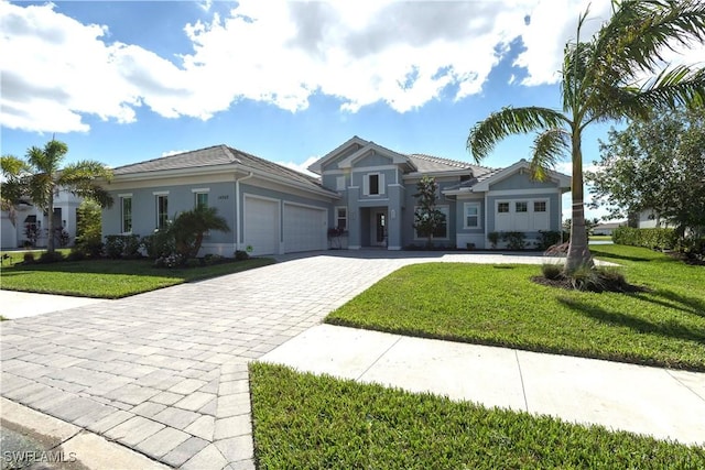 14248 Laguna Springs Ln, Naples, FL 34114 - view of front facade featuring a garage, decorative driveway, a front lawn, stucco siding, and a tile roof