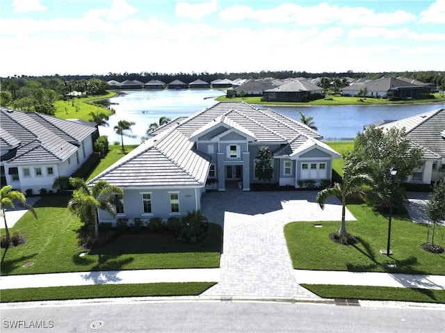 14248 Laguna Springs Ln, Naples, FL 34114 - view of front of house with a water view, a residential view, driveway, and a tile roof
