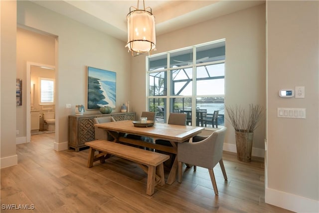 14248 Laguna Springs Ln, Naples, FL 34114 - dining area featuring a chandelier, light wood-type flooring, and baseboards
