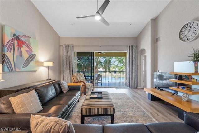 living room with high vaulted ceiling, visible vents, ceiling fan, and wood finished floors