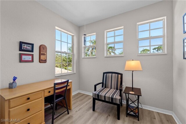 office area with light wood-style floors and baseboards