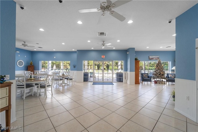 interior space featuring a healthy amount of sunlight, a wainscoted wall, visible vents, and light tile patterned flooring