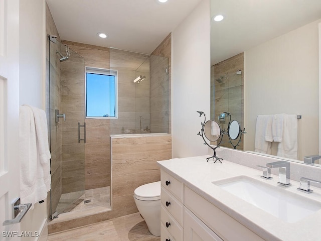 bathroom with vanity, toilet, and an enclosed shower