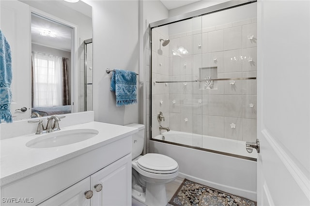 full bathroom featuring shower / bath combination with glass door, vanity, and toilet