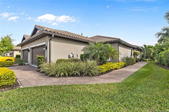 view of side of home featuring a yard and a garage