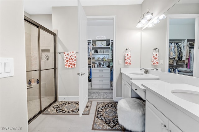 bathroom featuring tile patterned flooring, vanity, and a shower with door