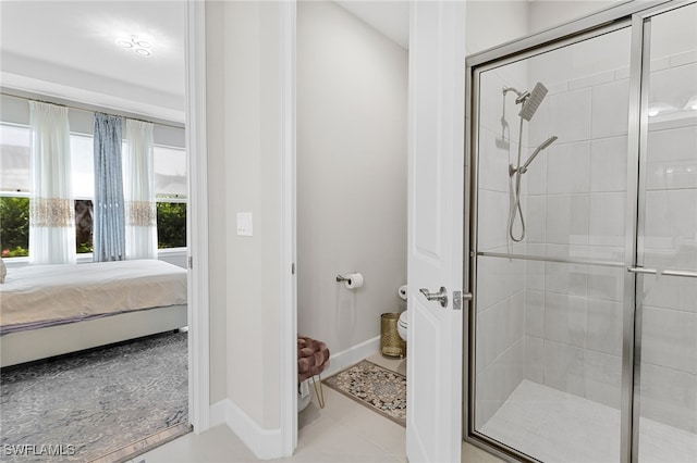 bathroom featuring tile patterned flooring, a shower with door, and toilet