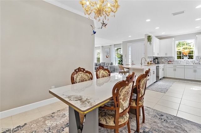 tiled dining room featuring ornamental molding, a notable chandelier, and sink