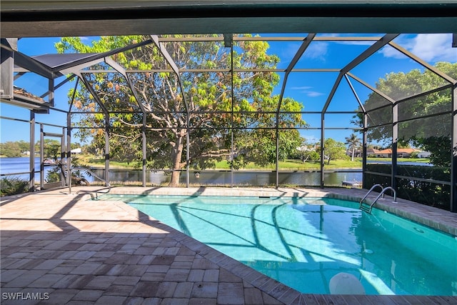 view of swimming pool with glass enclosure, a water view, and a patio