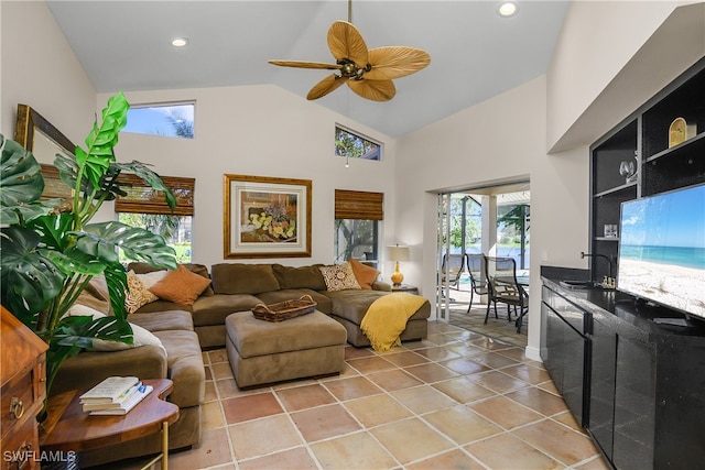 tiled living room with ceiling fan, sink, and high vaulted ceiling