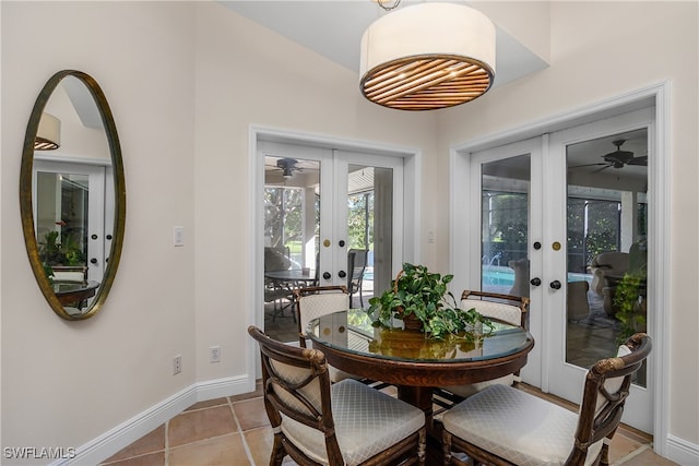 tiled dining room featuring ceiling fan and french doors