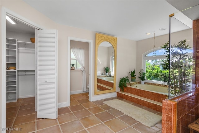 bathroom with tile patterned flooring and a bath